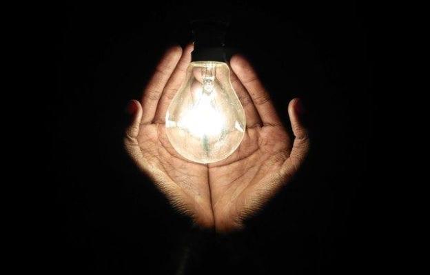 Person holding a lightbulb in hands