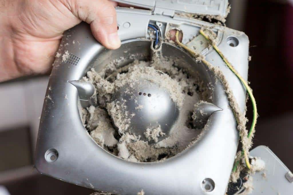 man holds dirty home air fan in his hands before birmingham duct cleaning