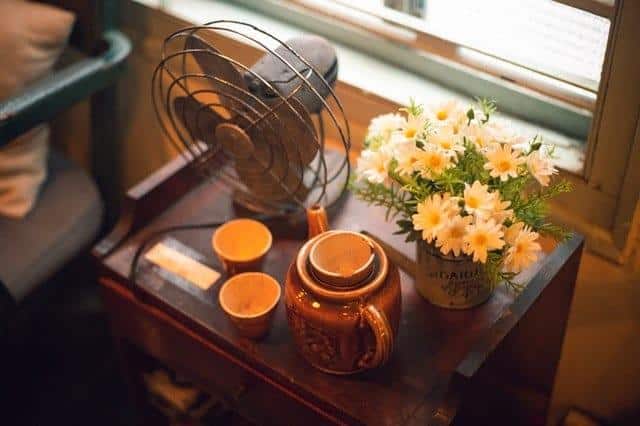 Fan, flowers, and tea on a side table