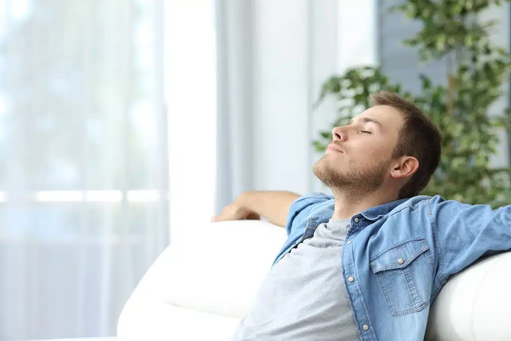 A man enjoys a comfortable humidity level in his Alabama home, courtesy of Xcalibur Services